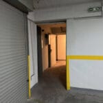 Διάδρομος υπογείου με ανοιχτή πόρτα και σήμανση εξόδου