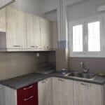Μικρή μοντέρνα κουζίνα με ξύλινα ντουλάπια και νεροχύτη