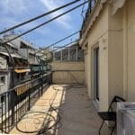 Μακρύ μπαλκόνι διαμερίσματος με τέντες και καλώδια
