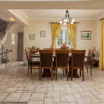 Φωτεινή τραπεζαρία με ξύλινο τραπέζι και κίτρινες κουρτίνες