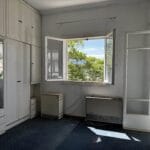 Φωτεινό δωμάτιο με ντουλάπες και ανοιχτό παράθυρο