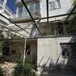 Παλαιά πολυκατοικία με μπαλκόνια και αυλή